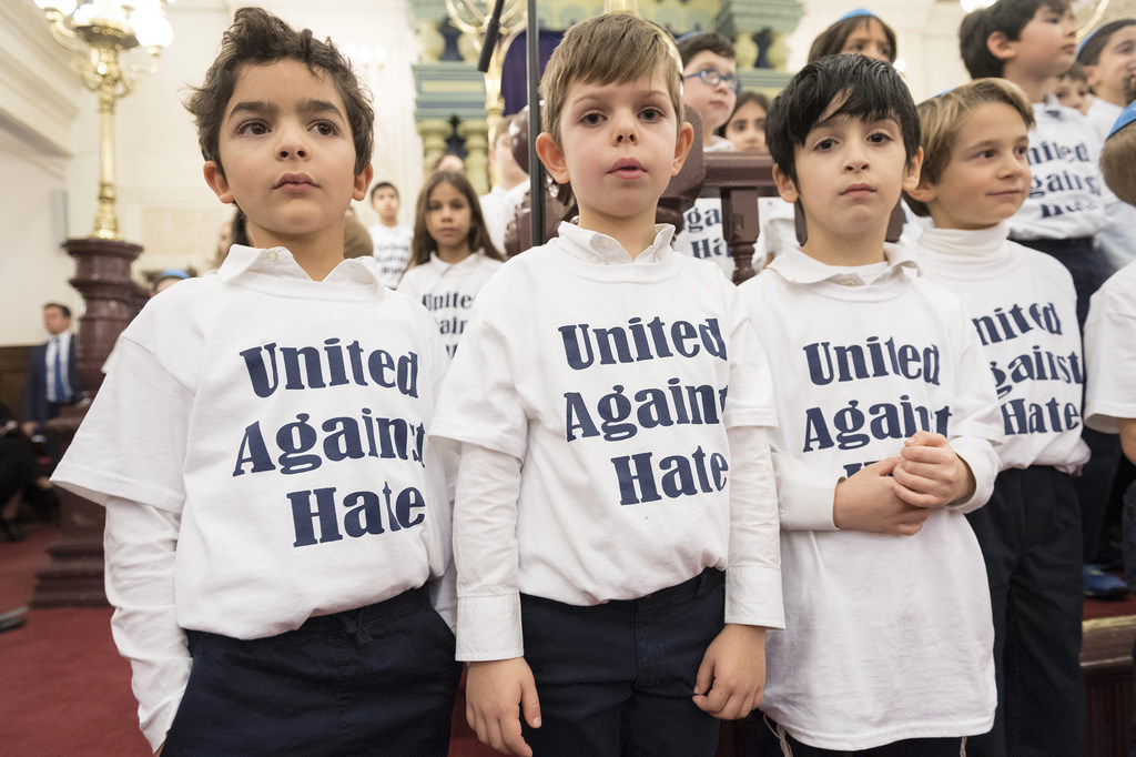 أطفال يرتدون قمصانا عليها شعار "متحدون ضد الكراهية" في فعالية جمعت بين أتباع الديانات المختلفة كنيس "بارك إيست" في مدينة نيويورك، تكريما لذكرى ضحايا هجوم على كنيس يهودي في مدينة بيتسبيرغ الأميركية..